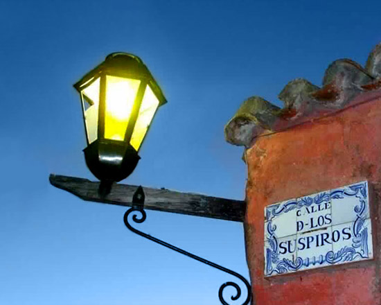 Farol y cartel de azulejos de la Calle de los Suspiros al atardecer