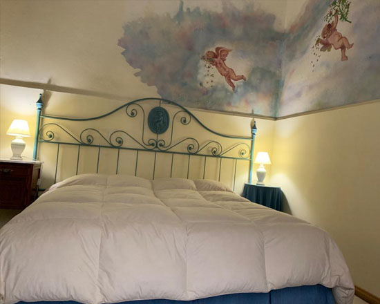 Habitación superior con cielorraso pintado con nubes y ángeles