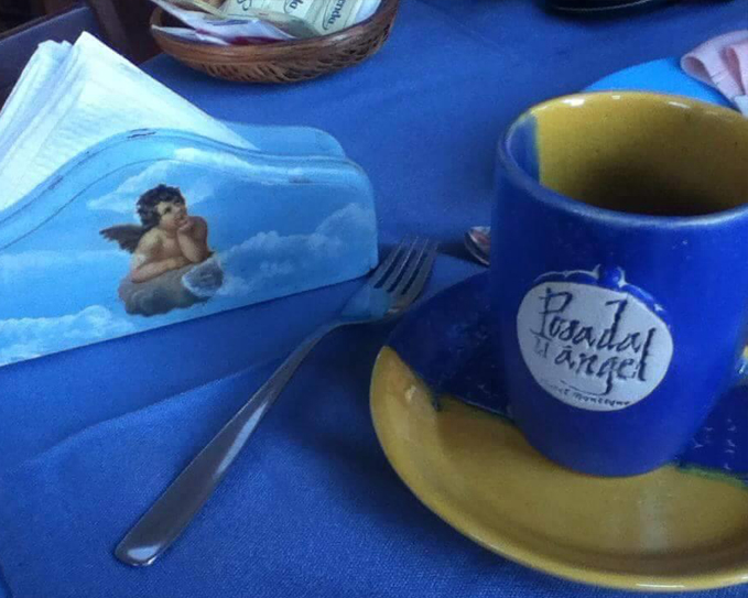 Taza de café con el nombre de la posada sobre una mesa